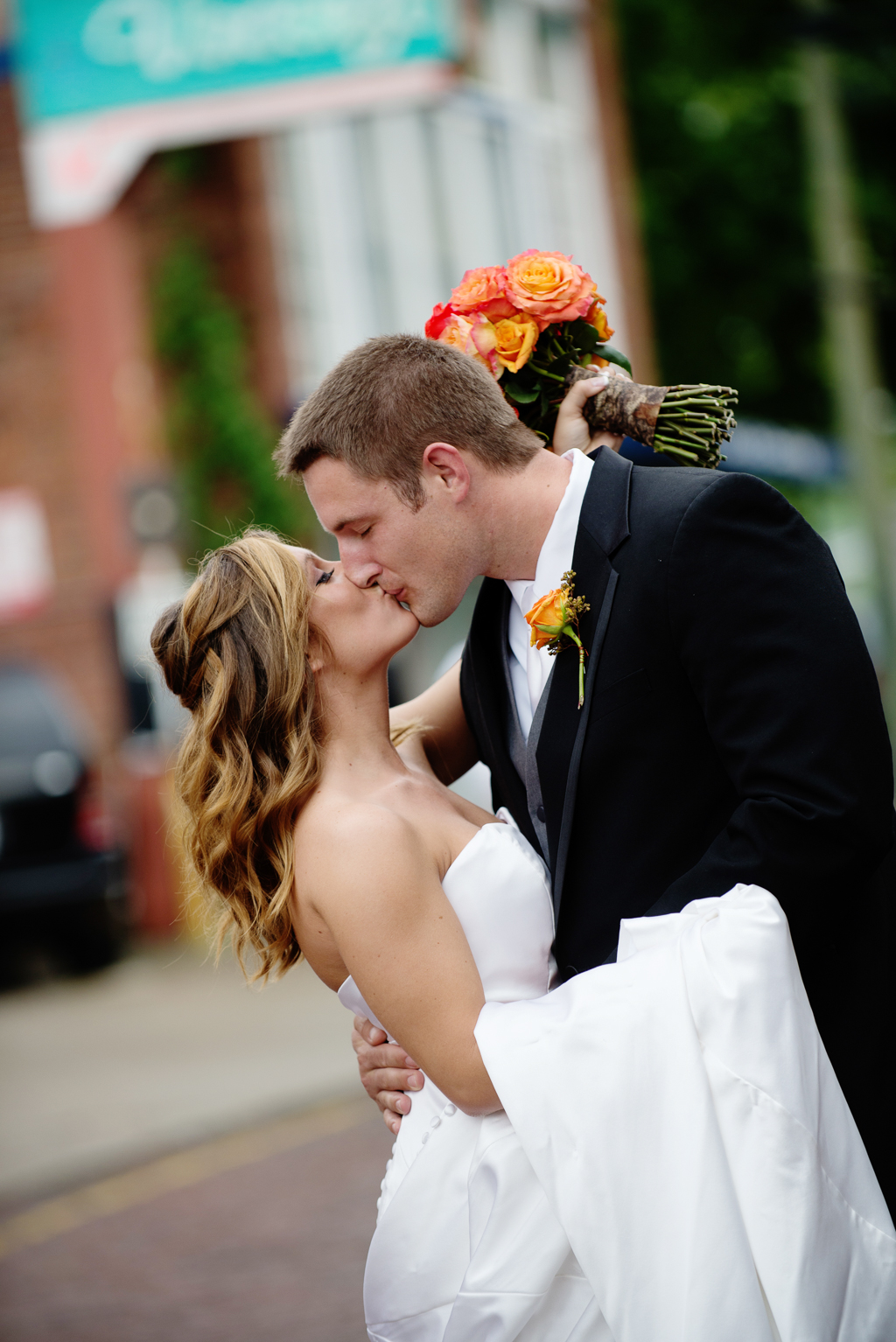 bride and groom kiss in the middle of the street