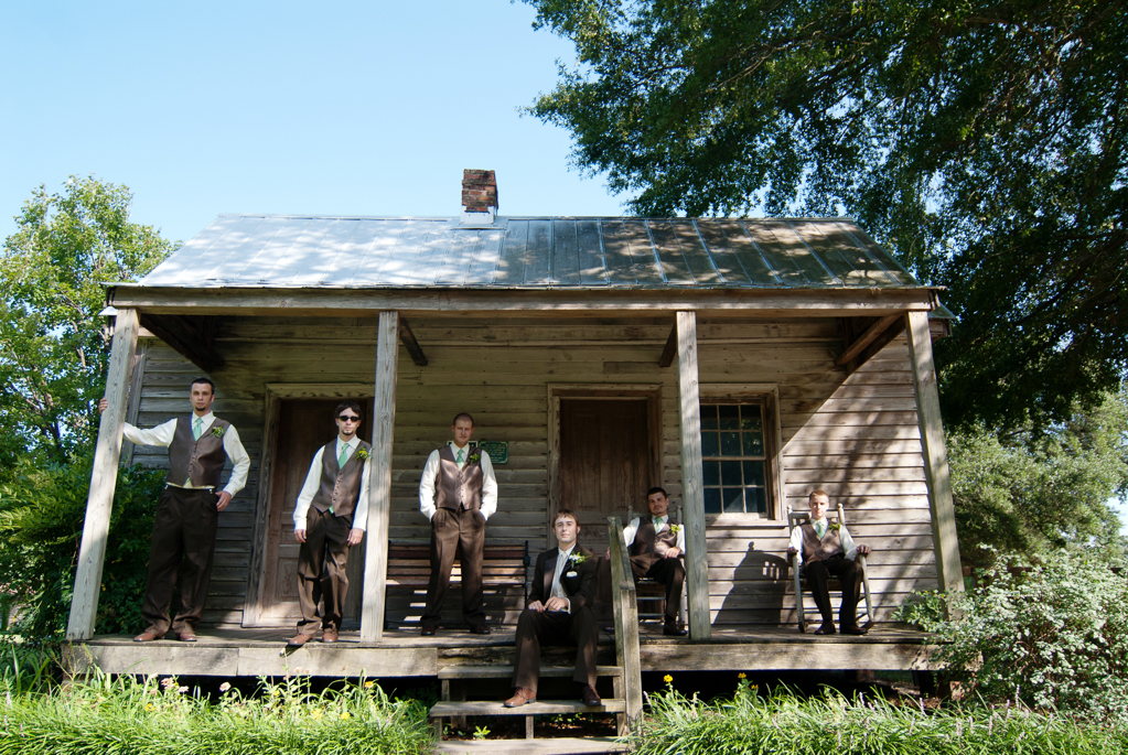 groomsmen sit on porch of old plantation house