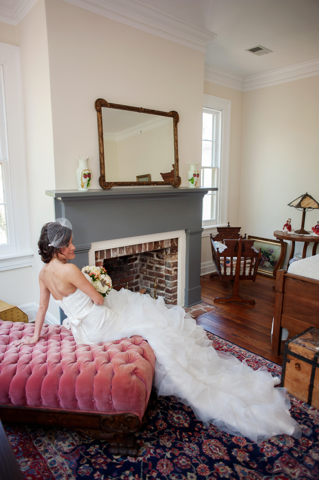 bride lounges on a pink tufted antique chaise in an old plantation bedroom
