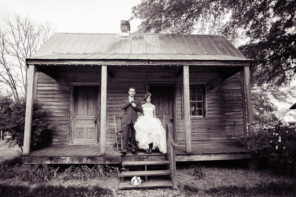bride and groom stand on front porch of old plantation cabin