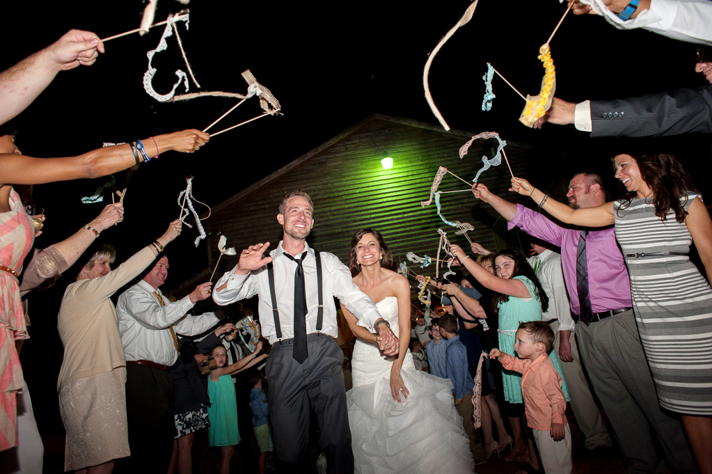 guests wave ribbon wands as bride and groom exit the wedding reception