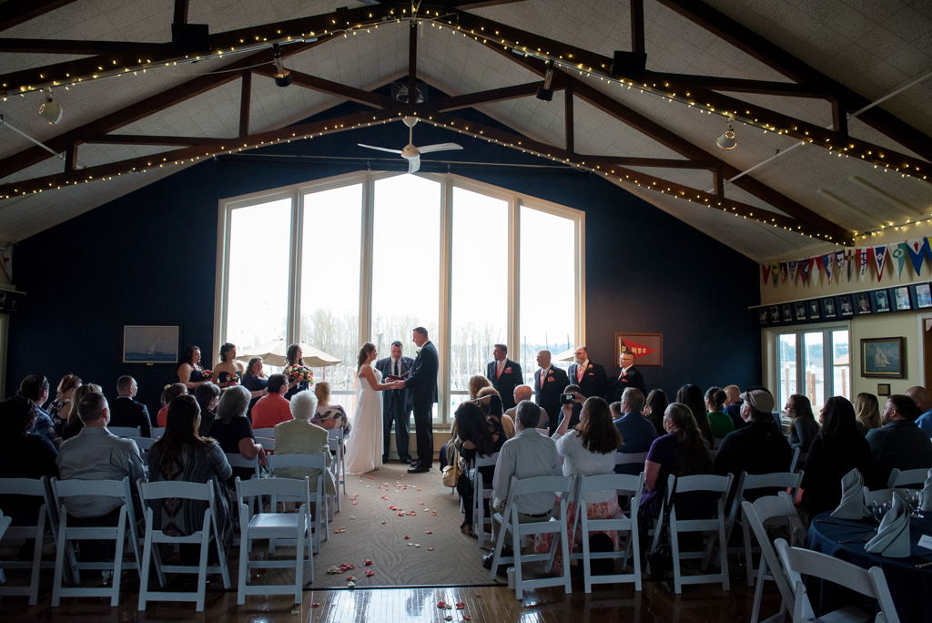 wedding ceremony in front of large windows at portland yacht club