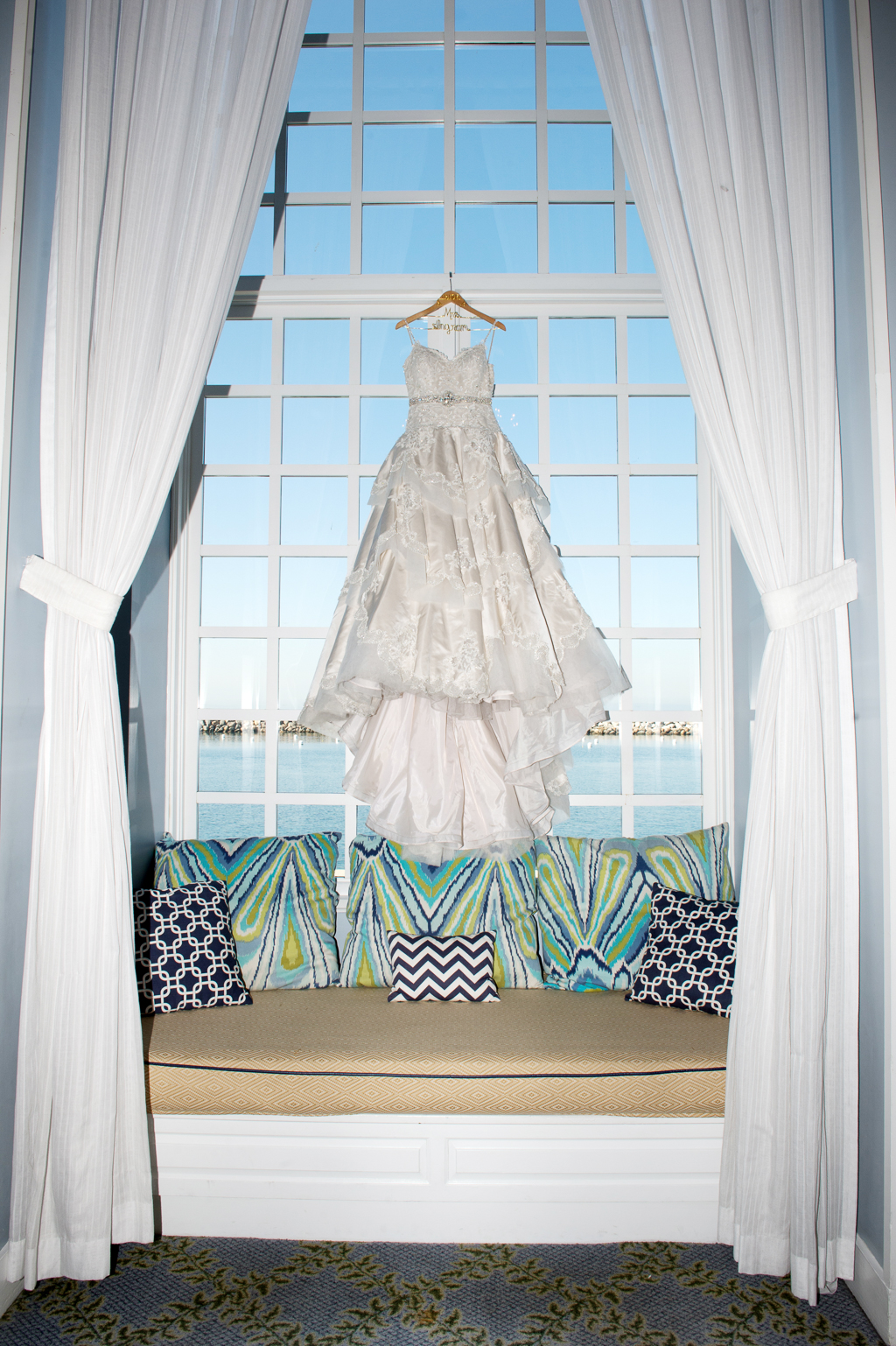 a wedding dress hangs in the window of the portofino hotel
