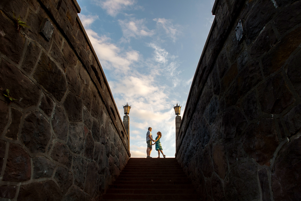 a couple hold hands and look at each other at the top of the stairs at Rocky Butte in Portland