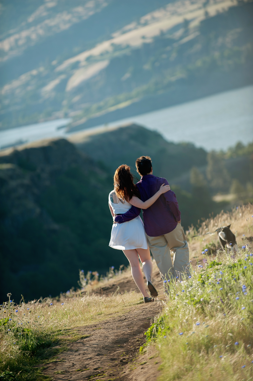 a couple walks with their arms around each other towards the columbia river gorge