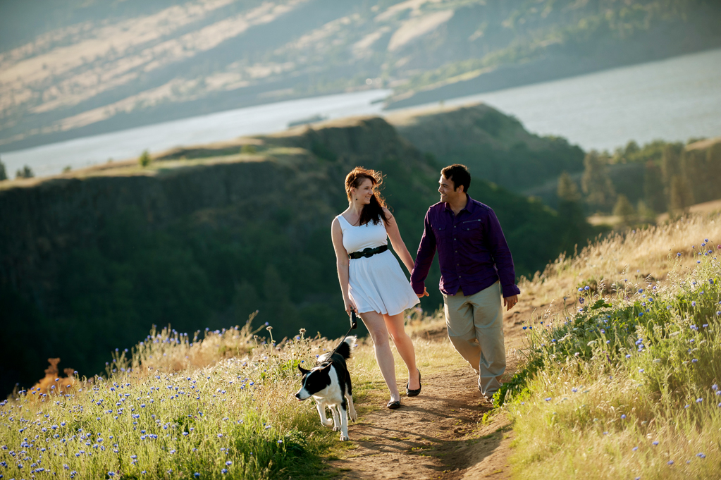 a couple and their dog walk hand in hand at rowena crest overlooking columbia river gorge