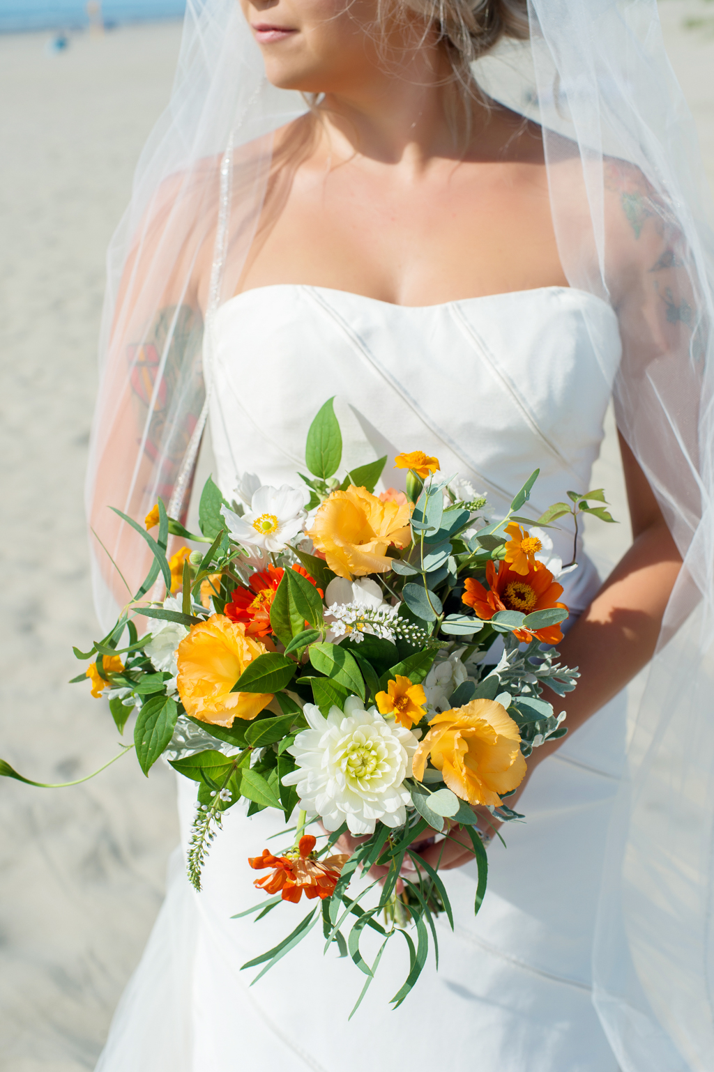 bride holds yellow and orange wedding bouquet
