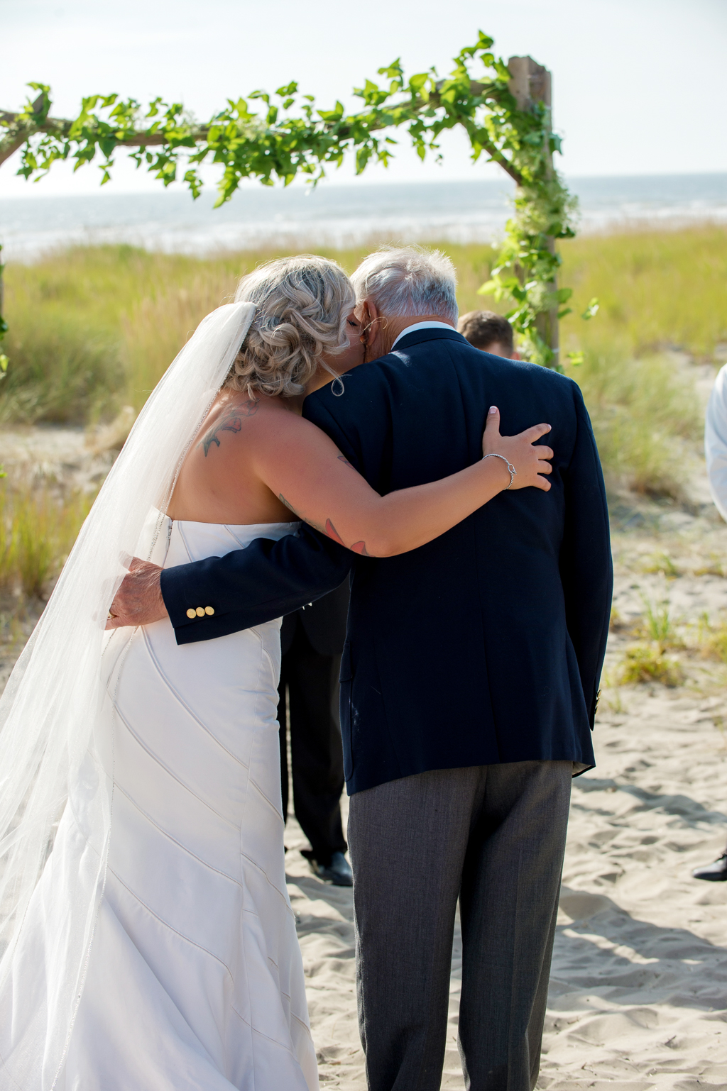a bride and her grandfather hug during wedding ceremony