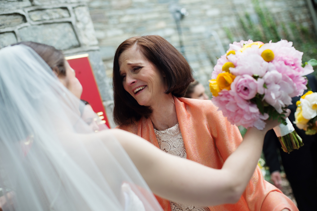 an emotional mother gives the bride a hug