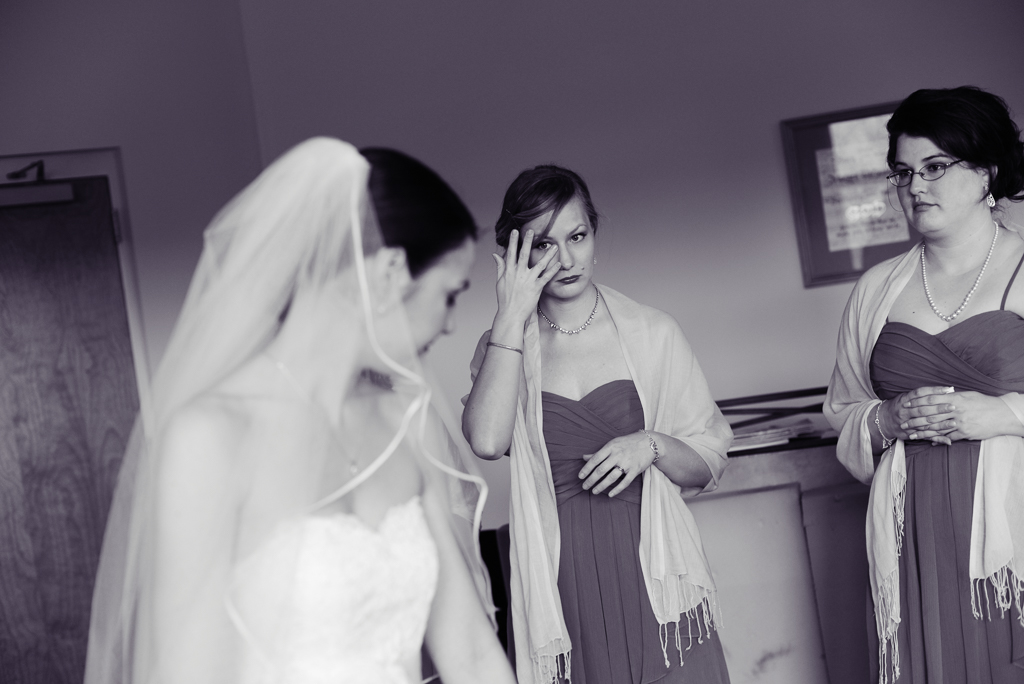 a bridesmaid cries while looking at the bride