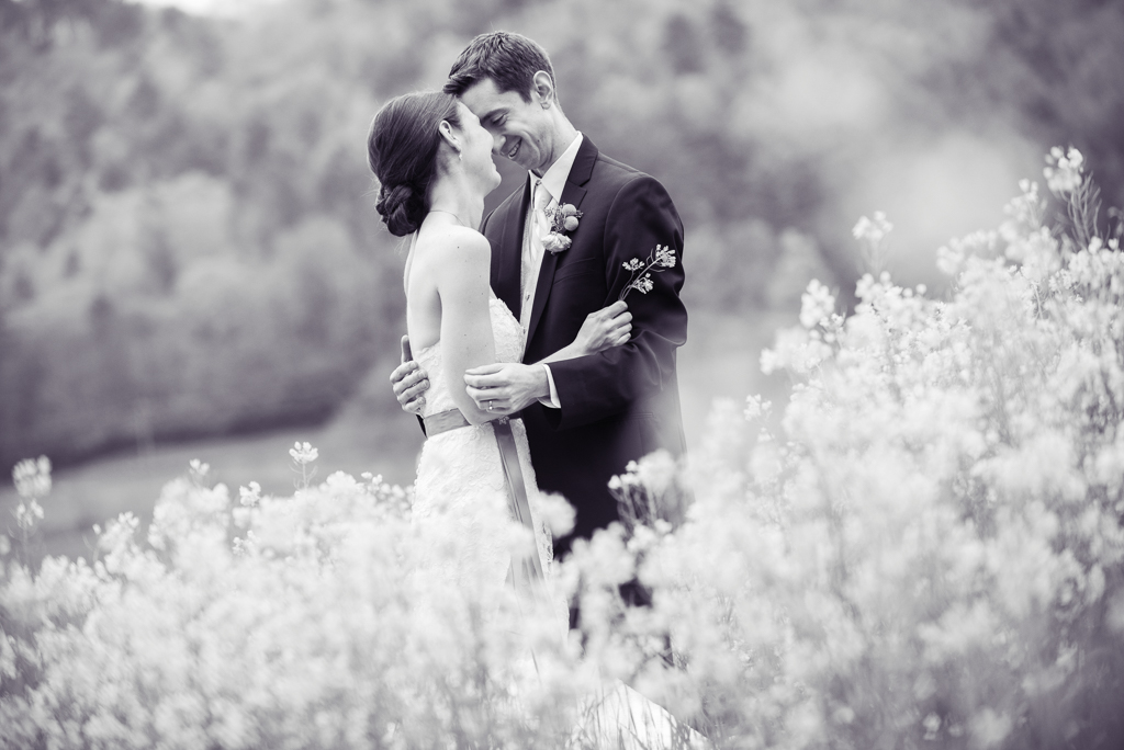 a bride and groom embrace in a field of yellow flowers