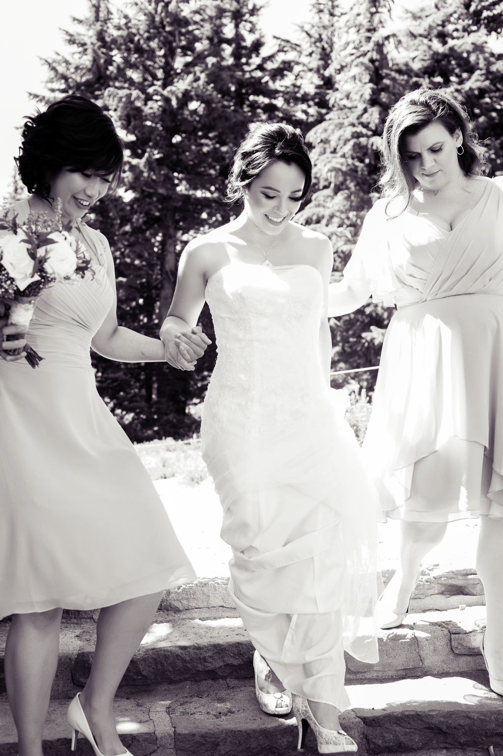 bridesmaids help bride down steps at timberline lodge