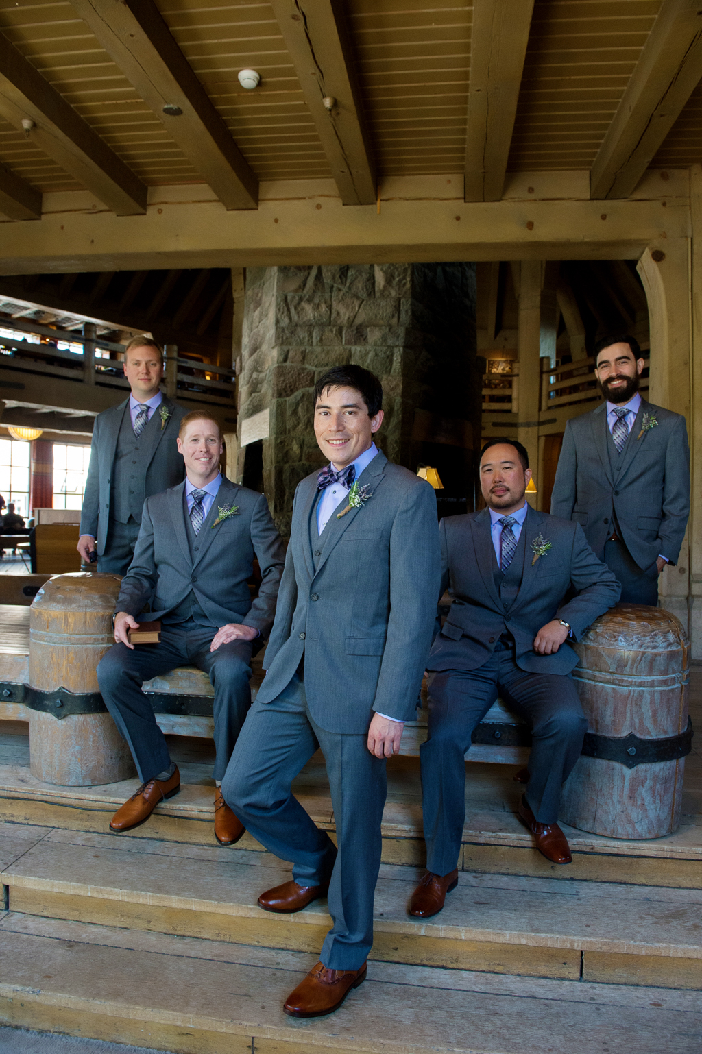 groomsmen in purple shirts pose in the lodge at timberline