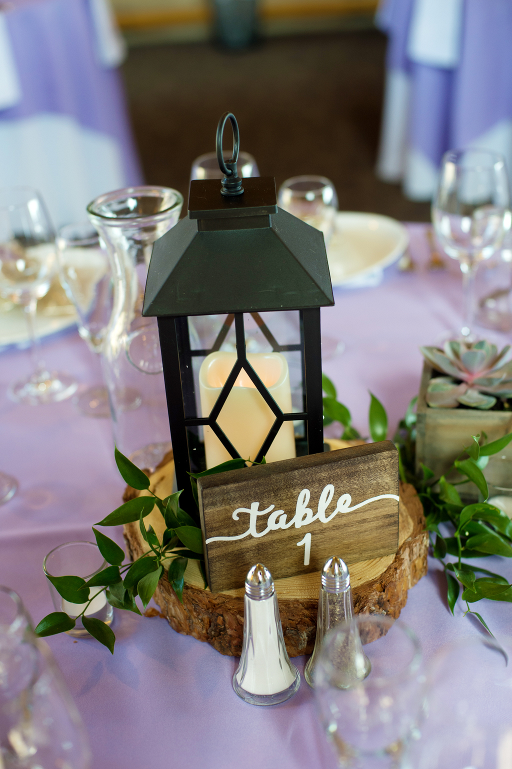 a lantern with a candle and a sign for table 1 at a wedding