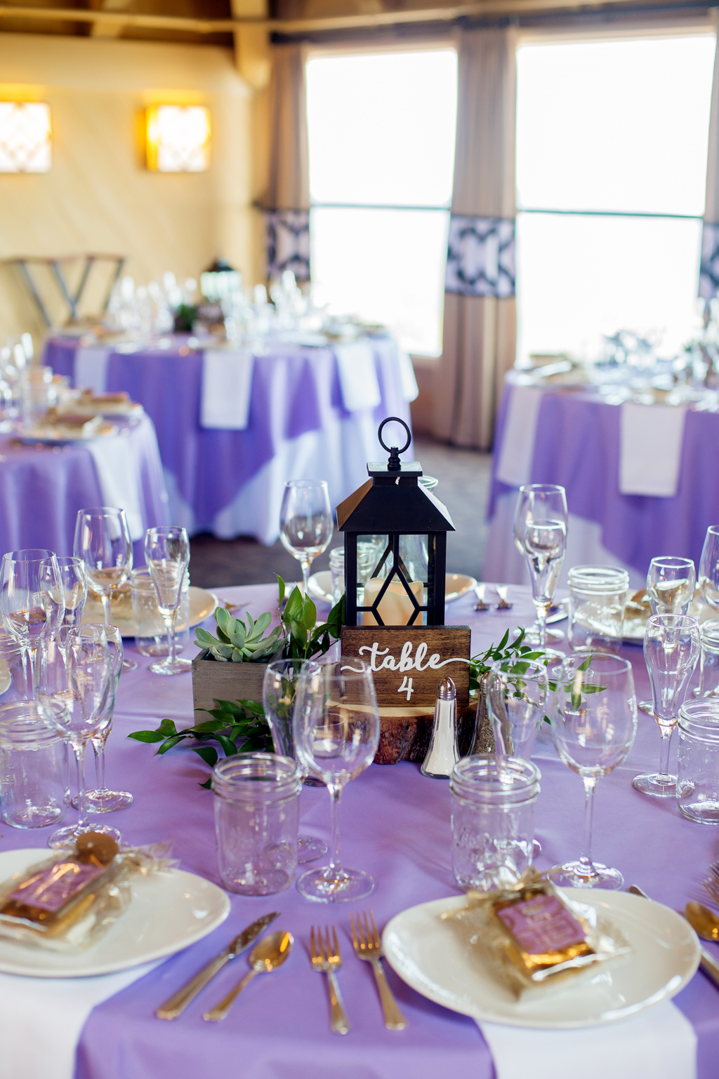 purple tables at a wedding reception with lanterns