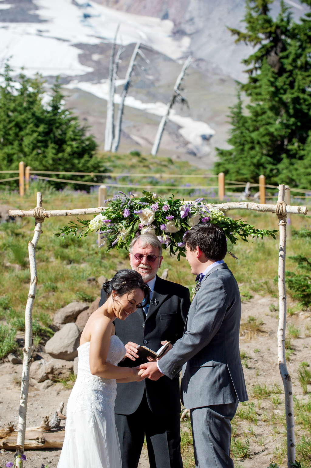 a wedding ceremony behind timberline lodge with mount hood towering above