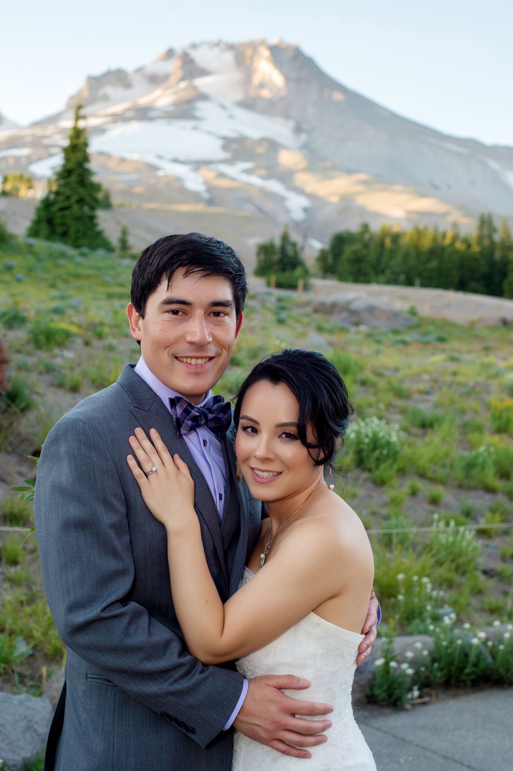 bride and groom pose in front of mount hood