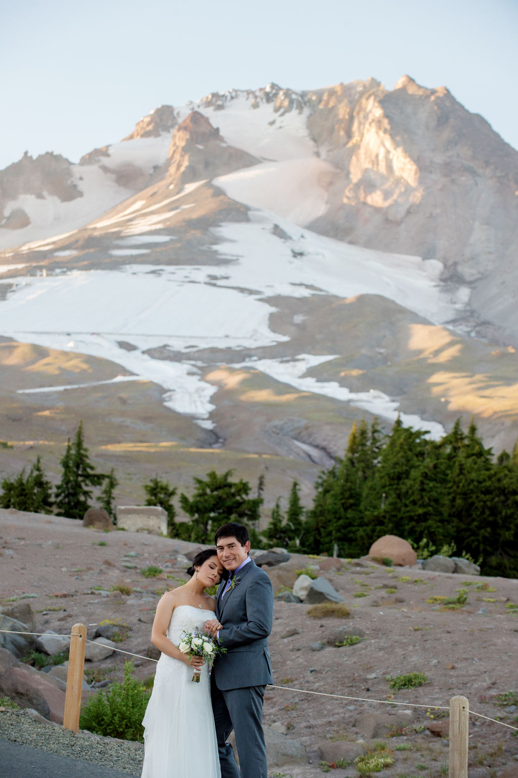 bride and groom embrace in front of mount hood