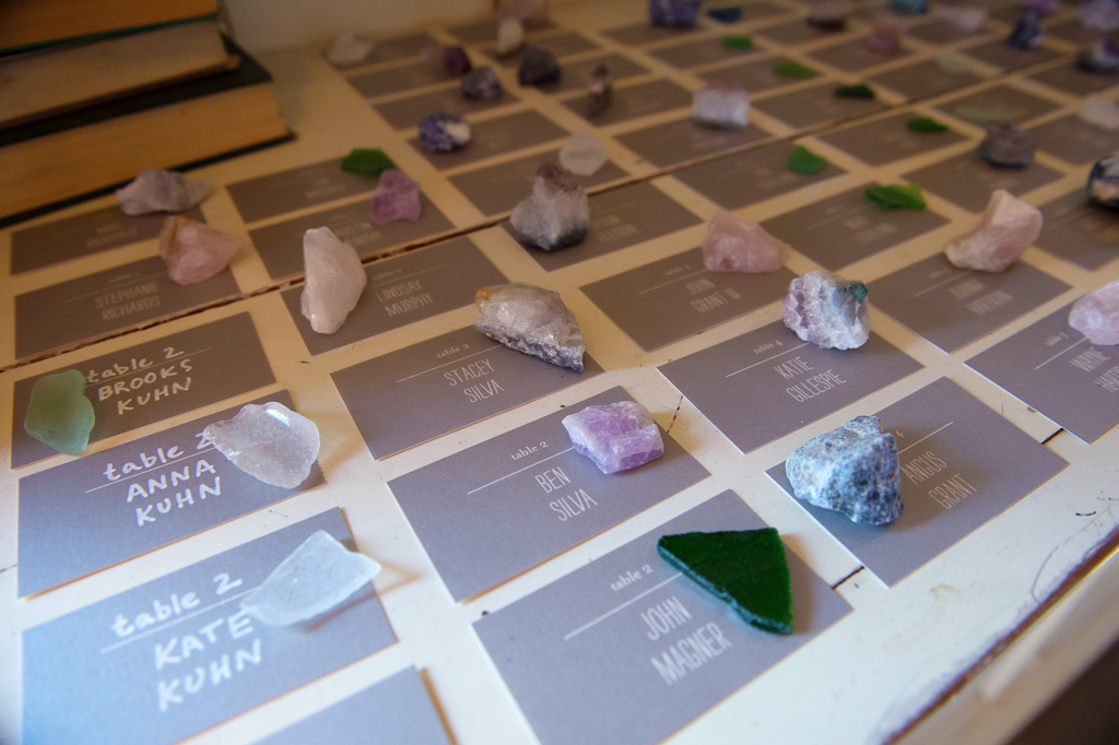 various stones and crystals sit on cards with wedding guests names for their favors