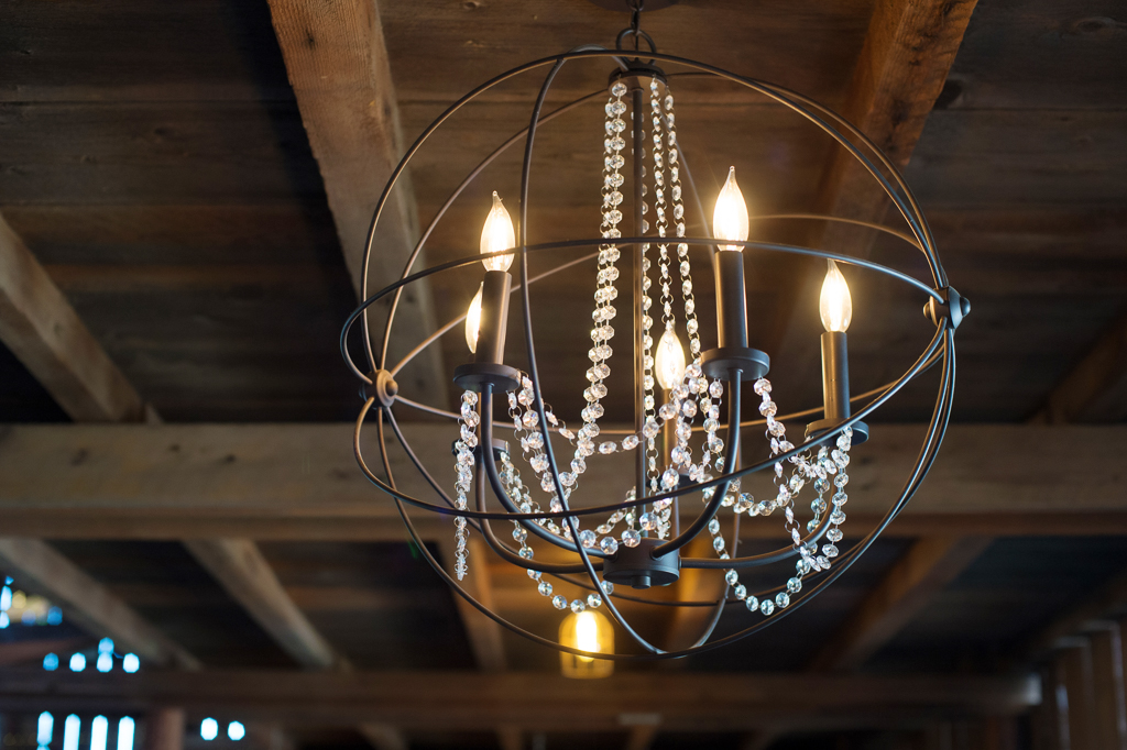 a unique chandelier hanging from the ceiling at the tin roof barn