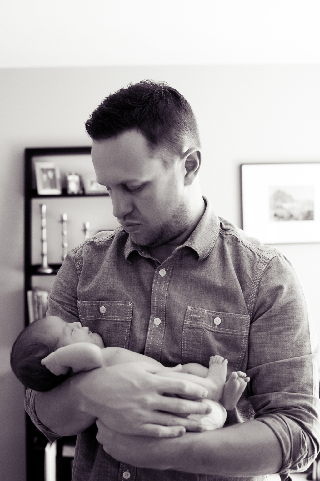 a dad holds his newborn baby