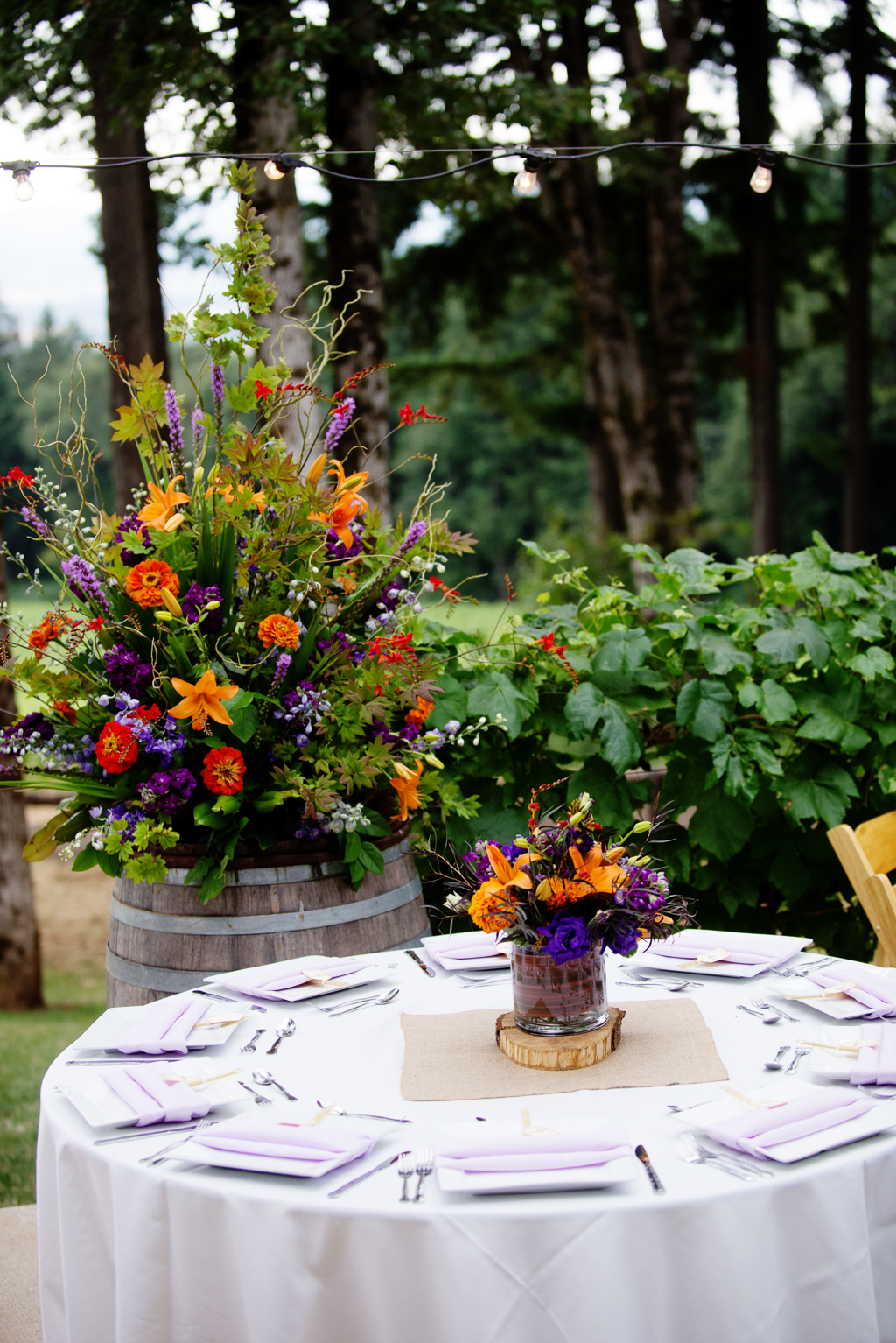 vibrant purple and orange flowers decorate the wedding reception