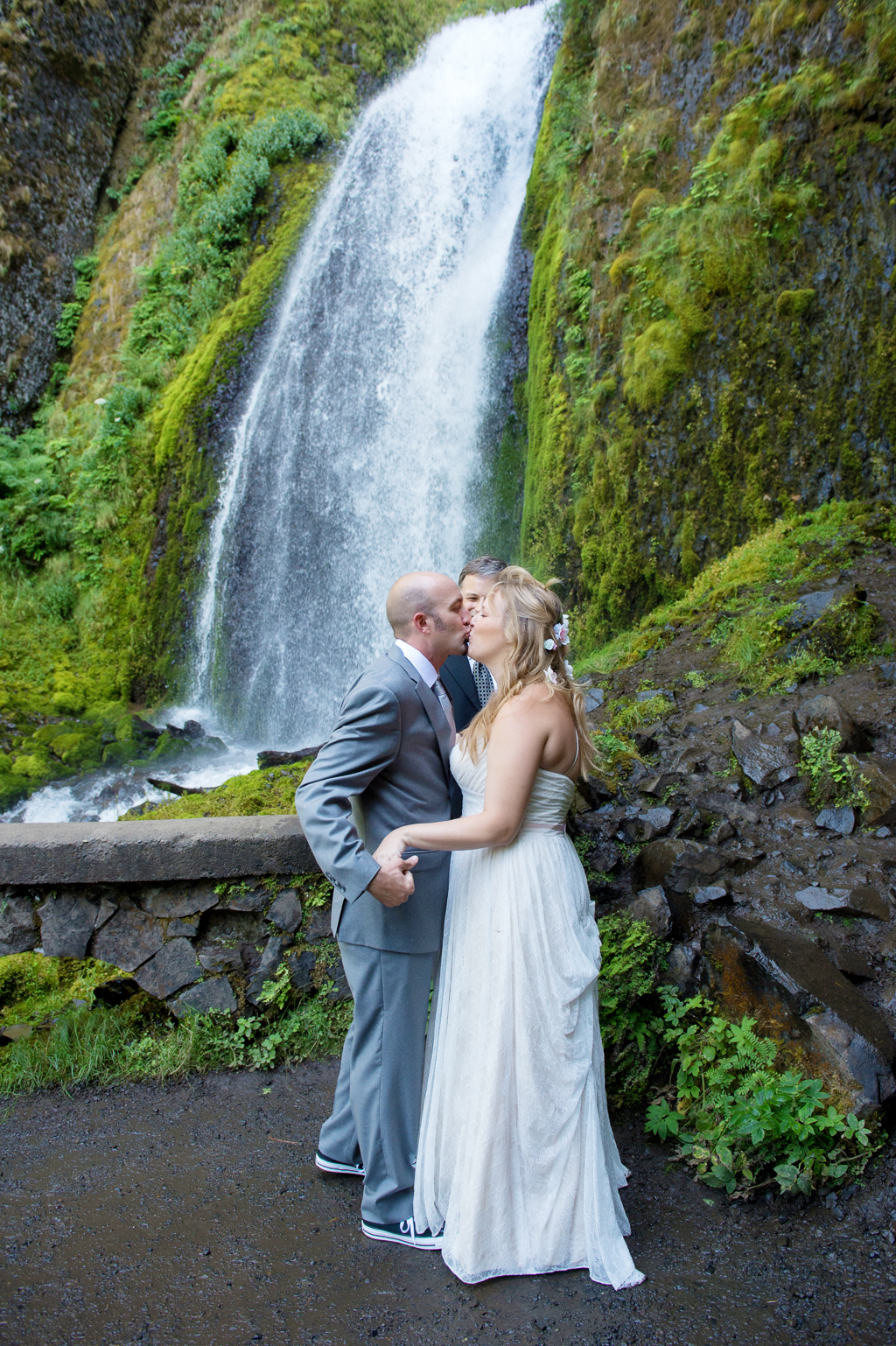 a just married bride and groom have their first kiss in front of wahkeena falls