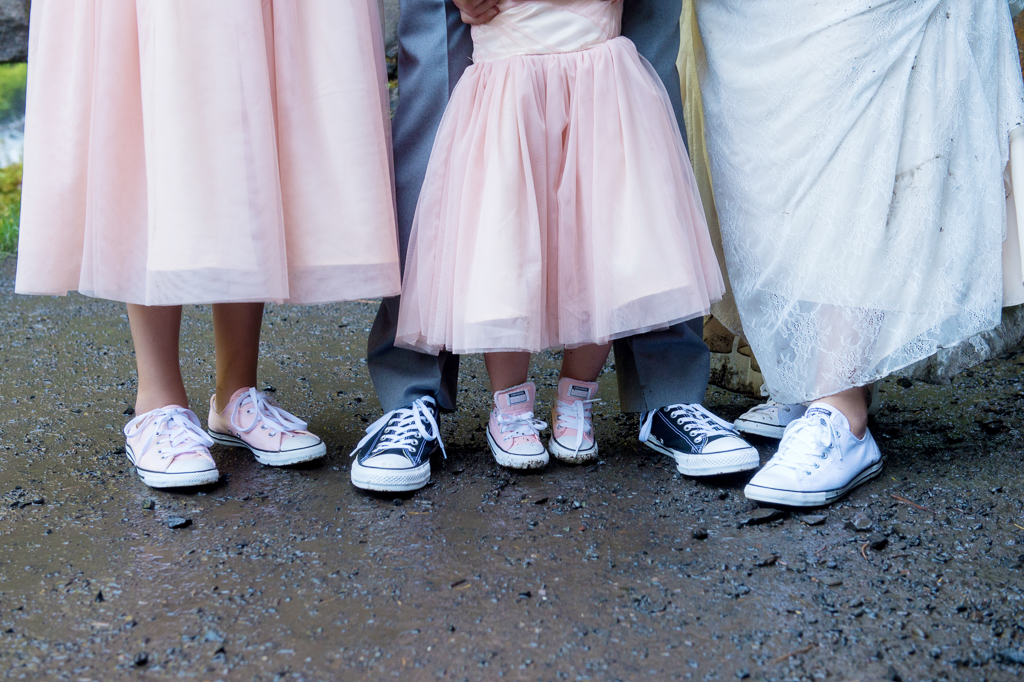a bride wears white converse, a groom wears black converse, and two girls in pink dresses wear pink converse