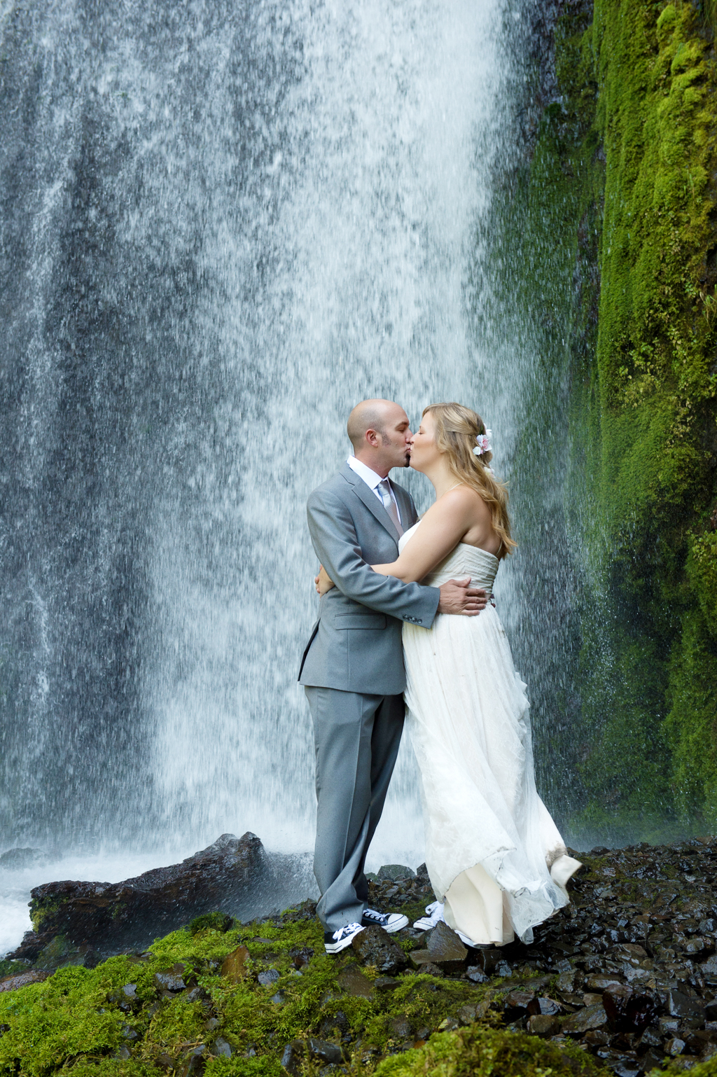 a bride and groom kiss in front of wahkeena falls