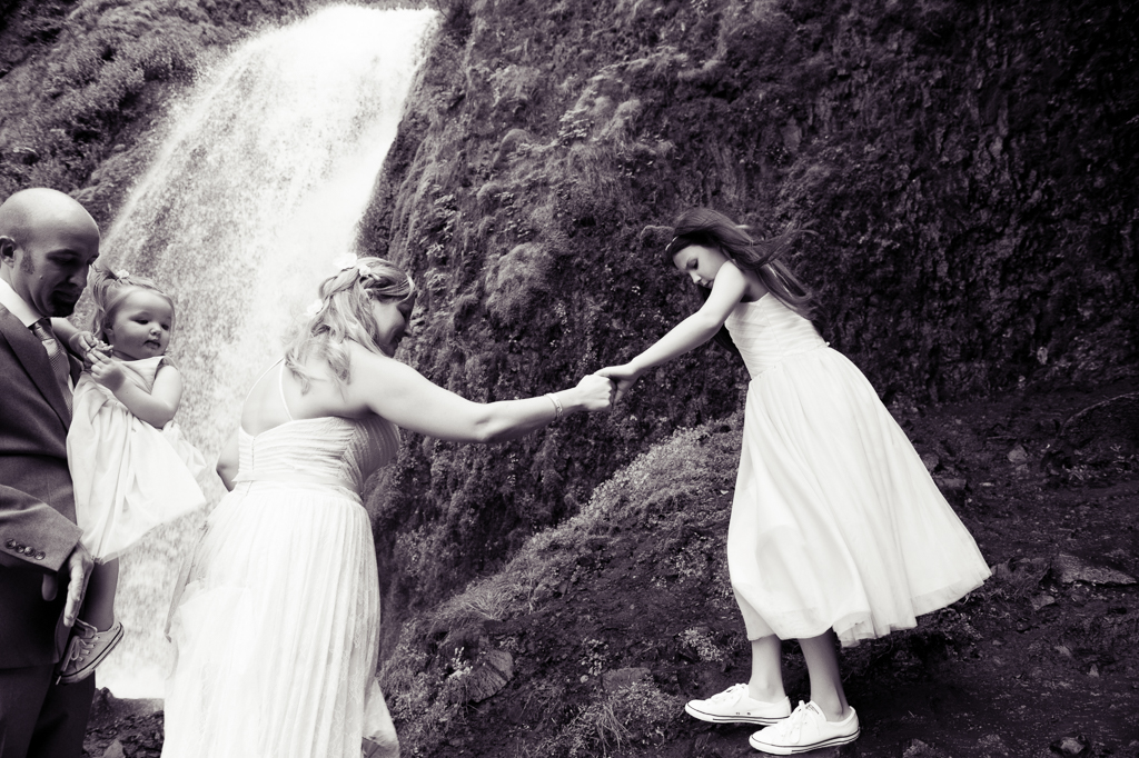 a bride helps her daughter off a rock at wahkeena falls