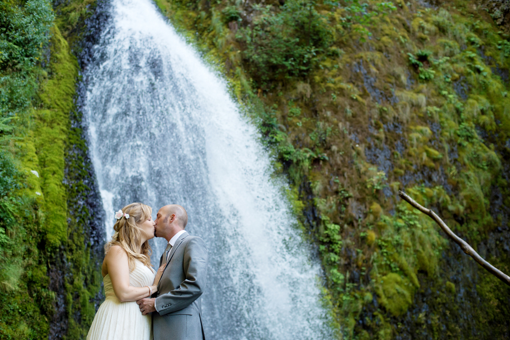 a bride and groom kiss at wahkeena falls