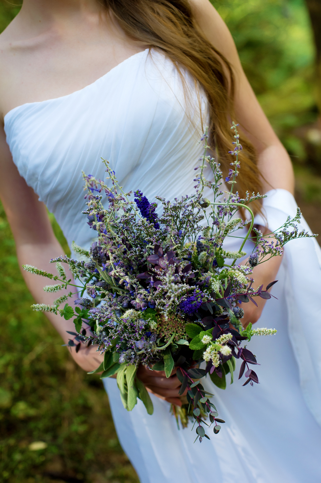 a bride holds a purple and lavender bouquet