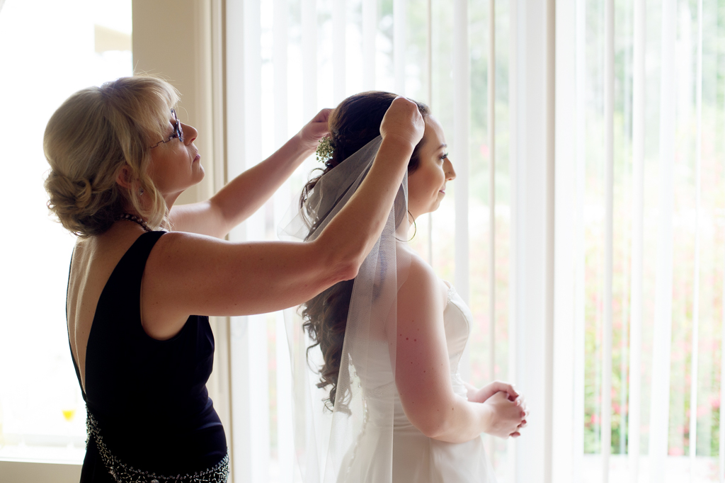 mom helps bride put in veil