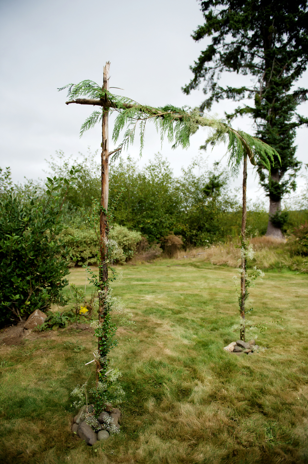 a fern covered wedding arbor made of sticks