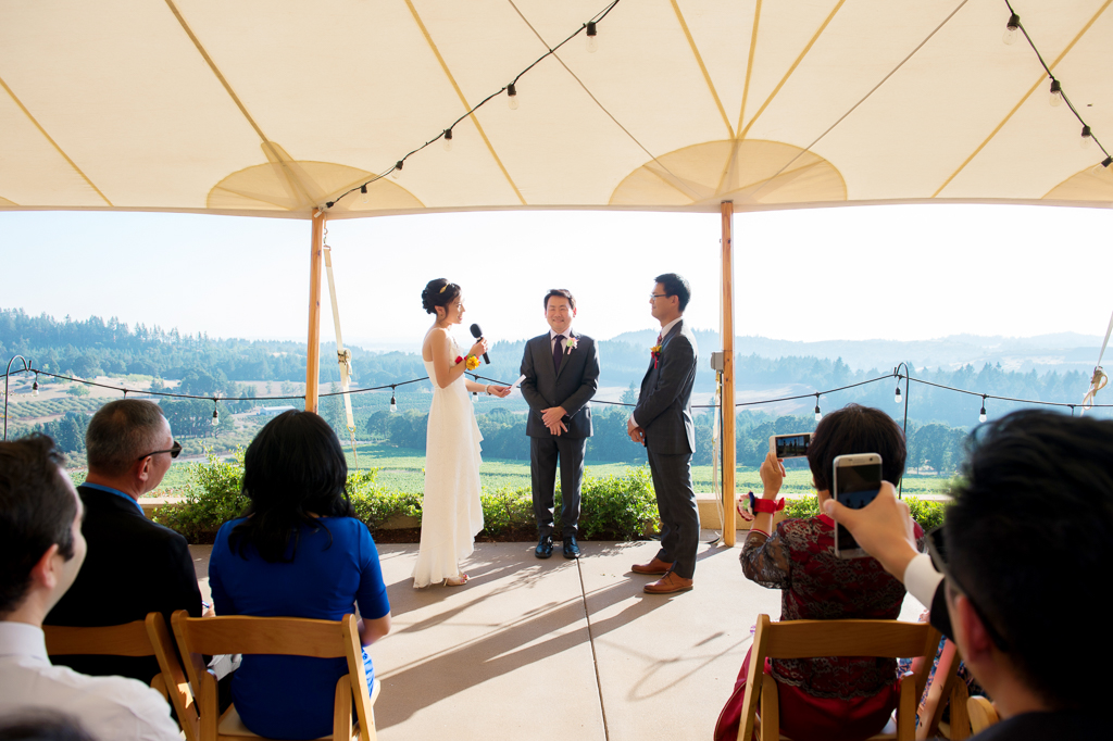 wedding ceremony underneath a tent overlooking willamette valley vineyards