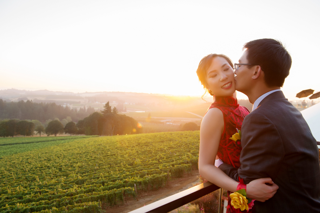 bride and groom kiss in the sunset over willamette valley vineyards