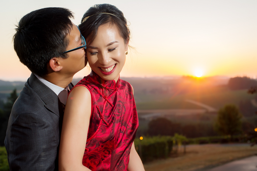 bride and groom kiss in the sunset over willamette valley vineyards