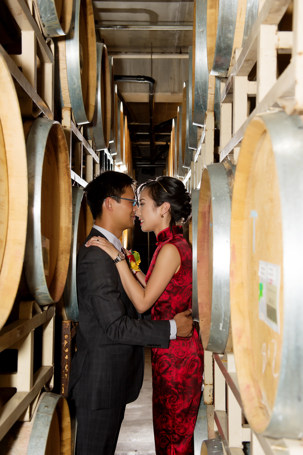 bride and groom kiss between the wine barrels