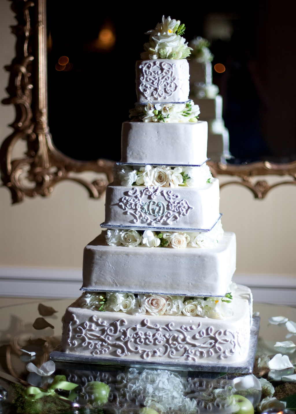 pretty 5 tier wedding cake with intricate icing design and ivory and green flowers