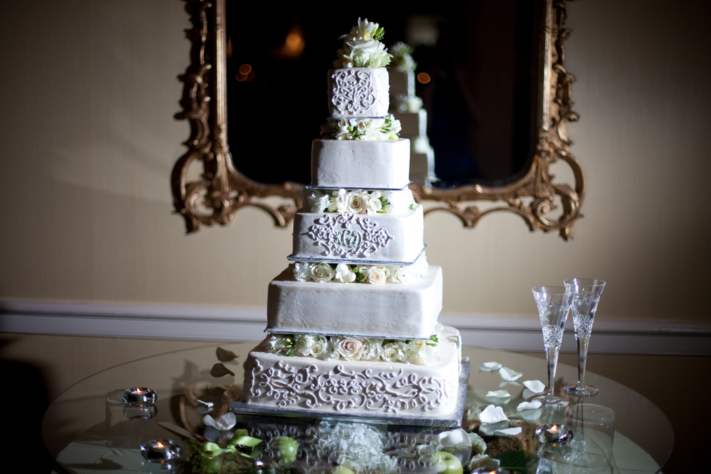 pretty 5 tier wedding cake with intricate icing design and ivory and green flowers