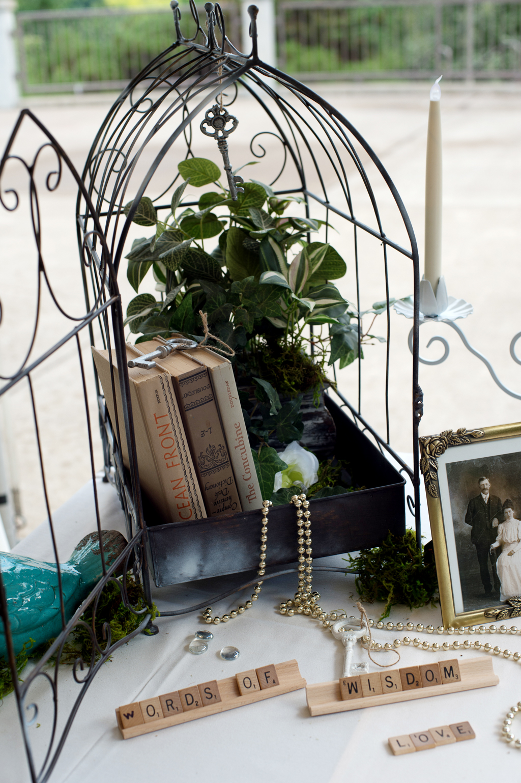 a birdcage filled with books and flowers decorates the wedding reception