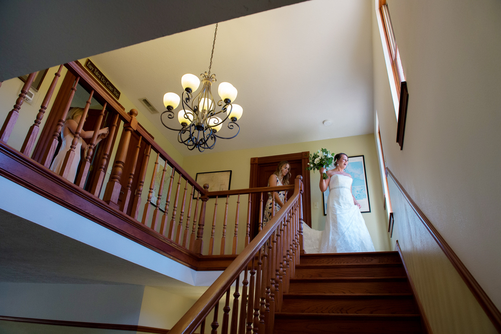 a bride looks out the window at the top of the staircase in youngberg hill house