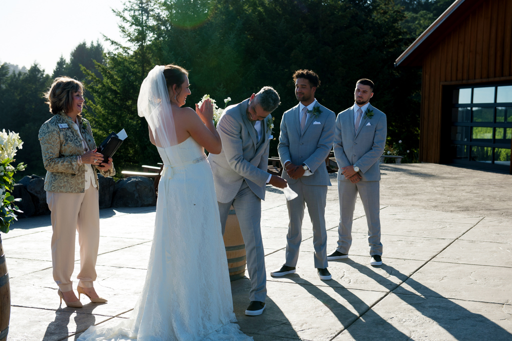 a groom swats at bumble bees to keep them off his bride during a wedding ceremony