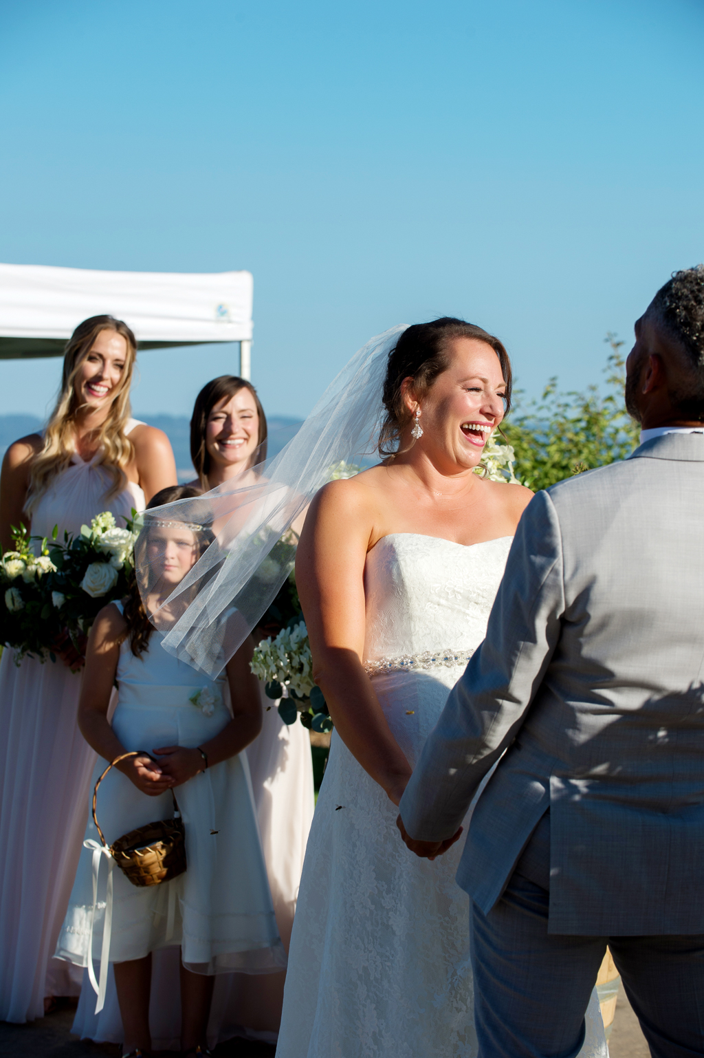 the bride and her bridesmaids laugh during a wedding ceremony