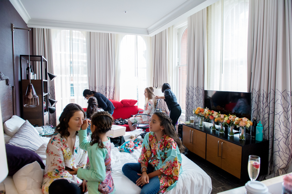 bridesmaids and the bride get ready in a room at hotel vintage