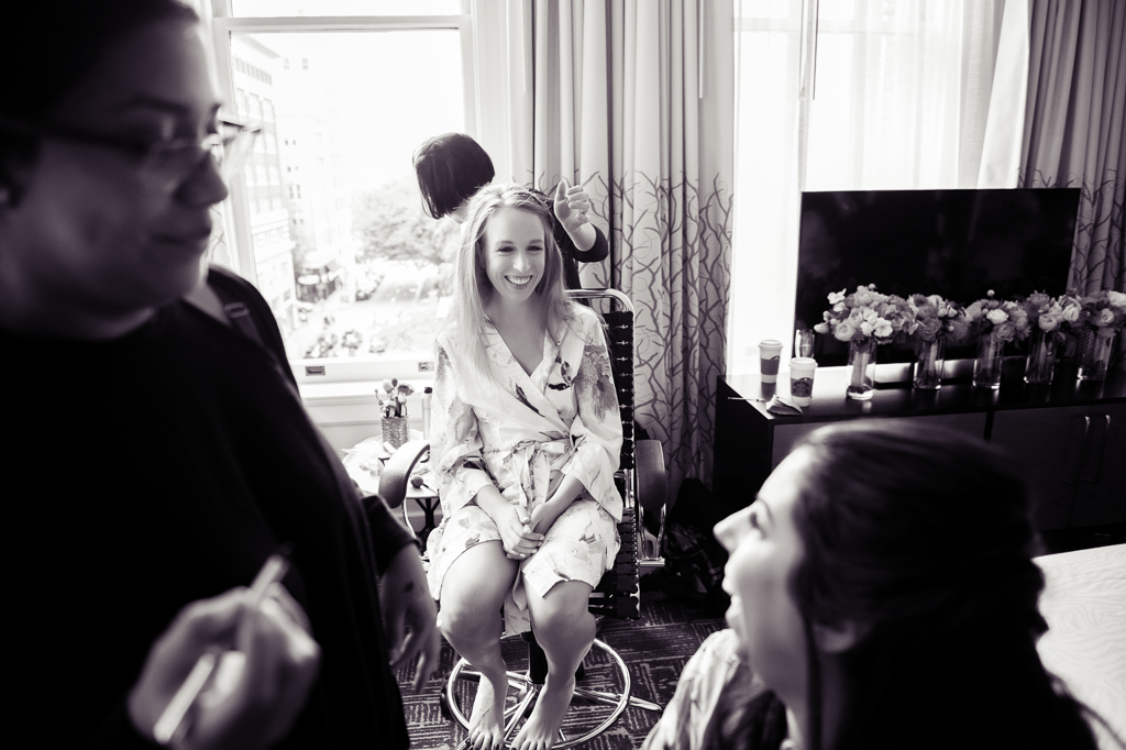 a bride getting ready at hotel vintage laughs at her bridesmaids