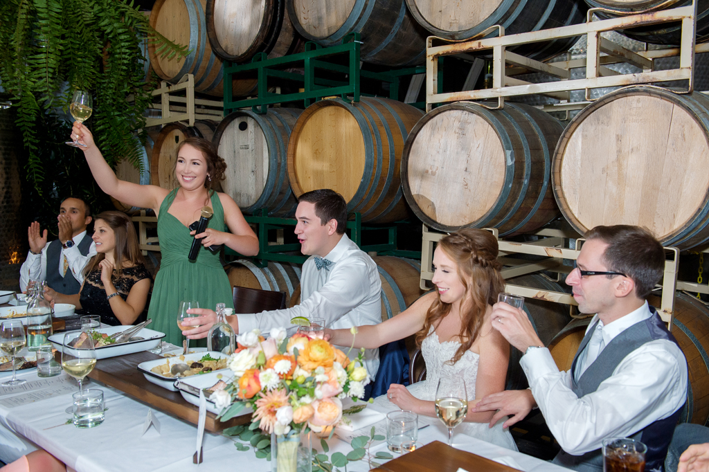 maid of honor in green bridesmaid dress gives a toast to the couple at coopers hall