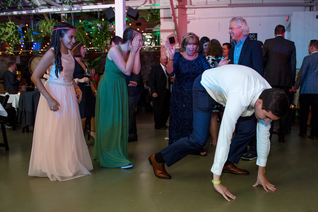 a bridesmaid's boyfriend dances with his butt in the air on all fours and she covers her mouth in shock