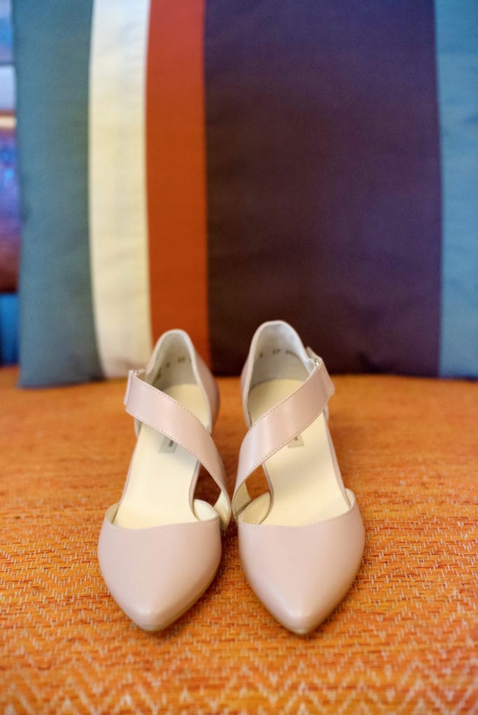 pink nude wedding shoes sit on an orange fabric