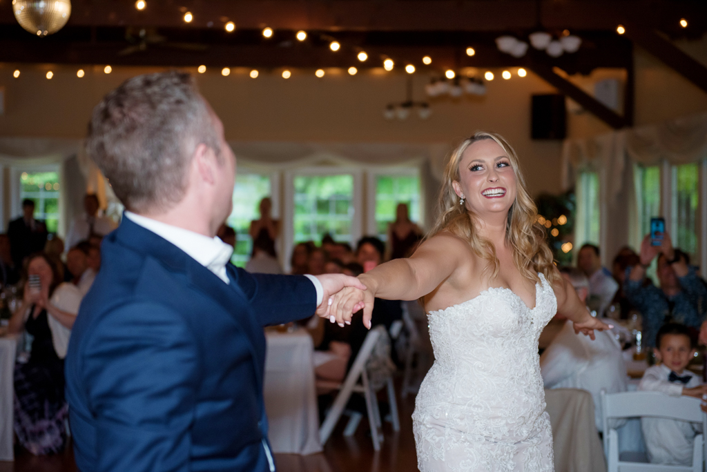 a bride and groom have their first dance at the laurelhurst club as guests watch